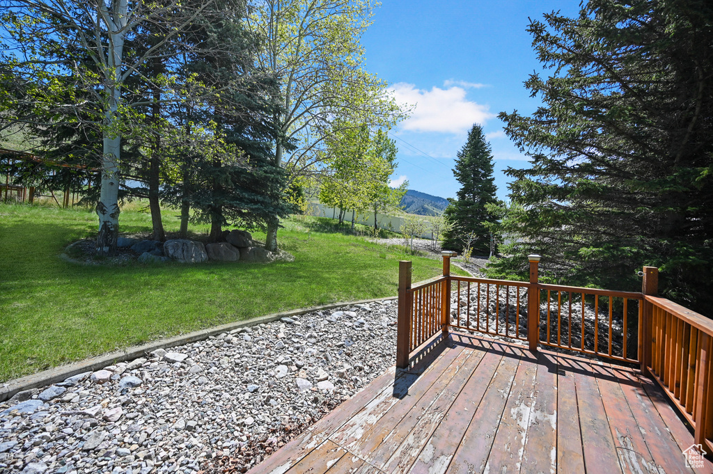 Deck with a lawn and a mountain view