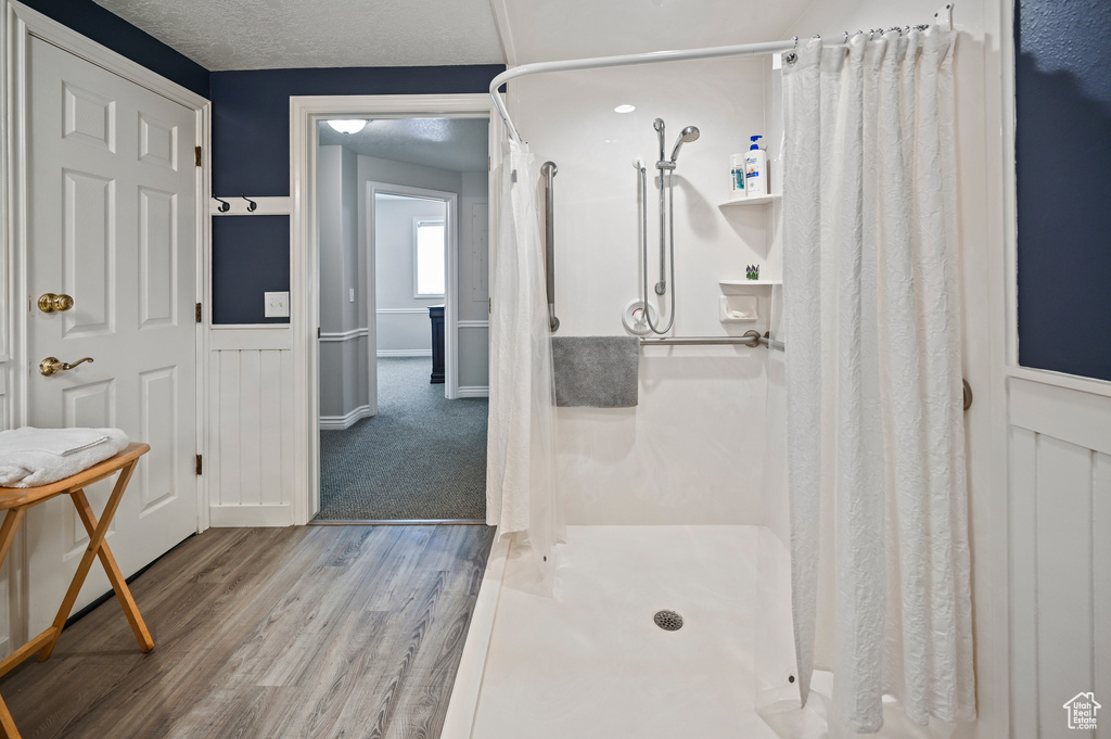 Full bath featuring a shower stall and wood finished floors