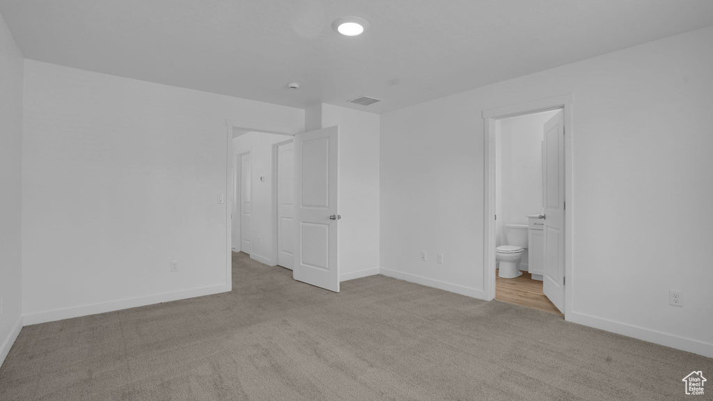 Unfurnished bedroom with carpet, baseboards, and connected bathroom