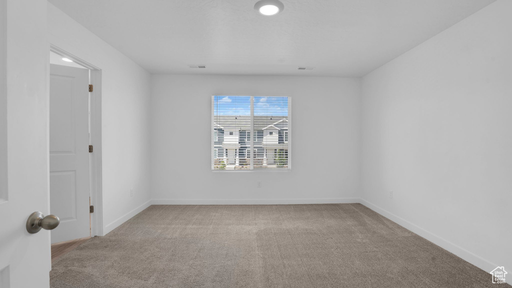Carpeted spare room with baseboards and recessed lighting