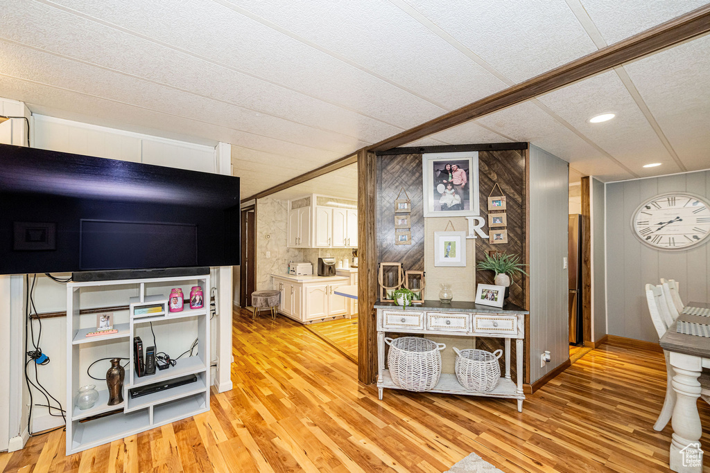 Bedroom featuring light wood-style floors, recessed lighting, a textured ceiling, wood walls, and baseboards