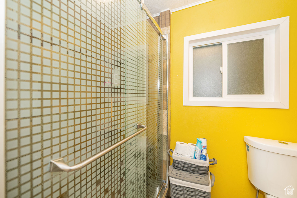Full bath featuring a shower stall and toilet