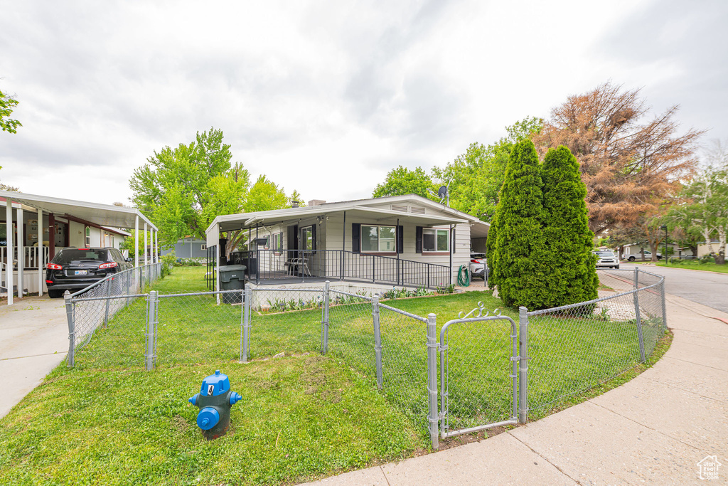 View of front of home featuring an attached carport, a gate, and covered porch