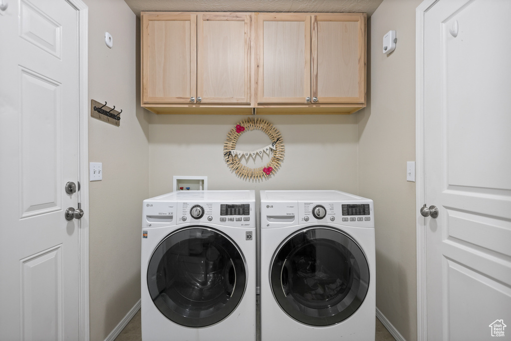 Laundry area featuring cabinet space, washer and clothes dryer, and baseboards