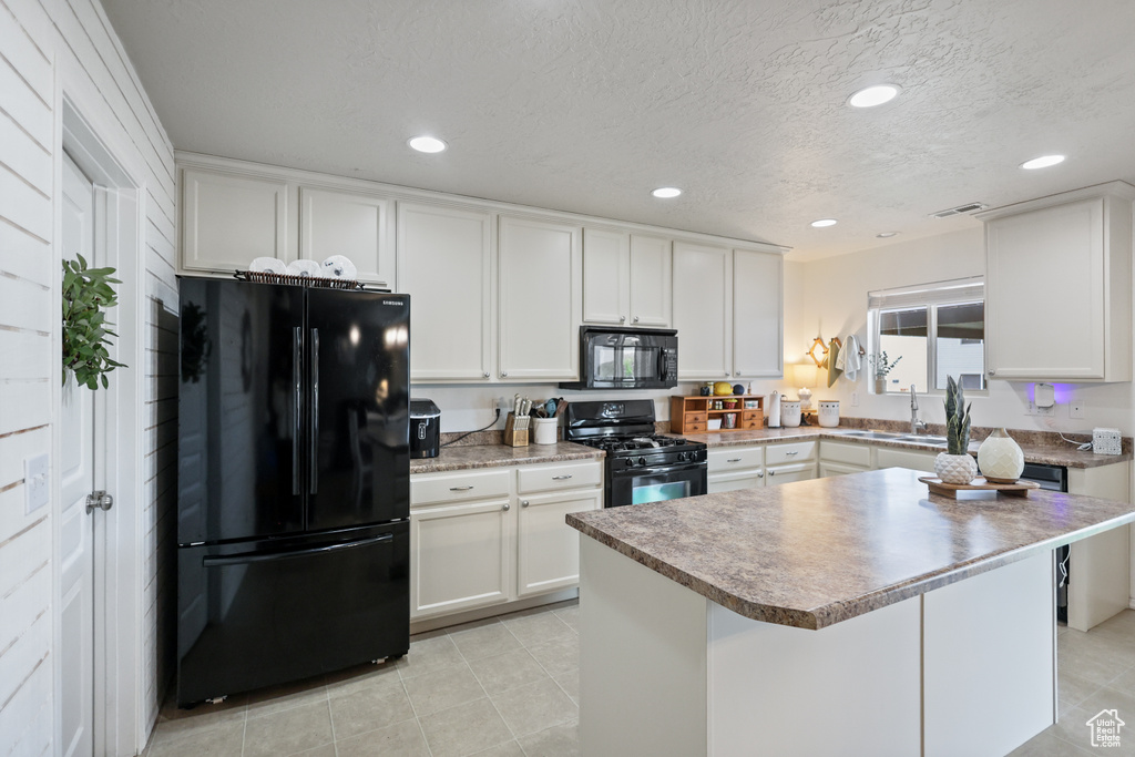 Kitchen featuring black appliances, white cabinets, a sink, recessed lighting, and light tile patterned floors