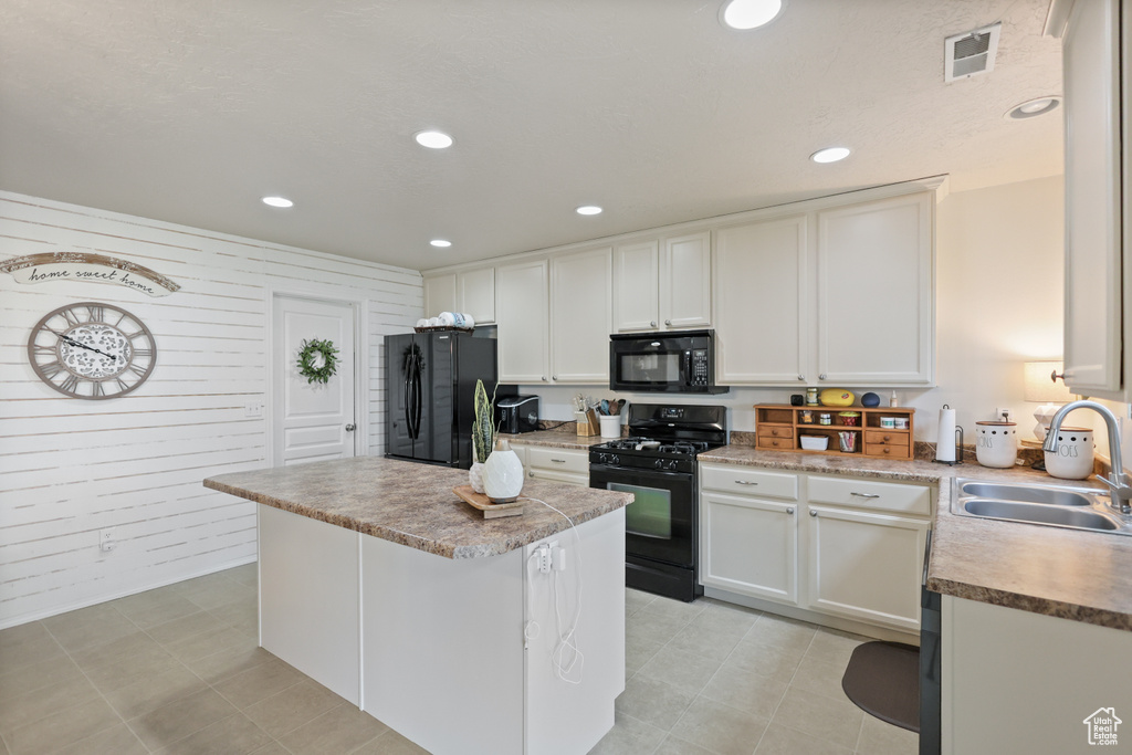 Kitchen with black appliances, a sink, a center island, recessed lighting, and white cabinets