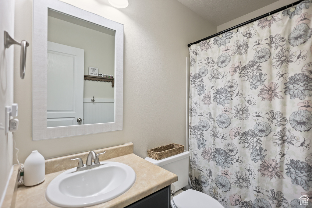 Full bathroom with vanity, toilet, and a shower with shower curtain