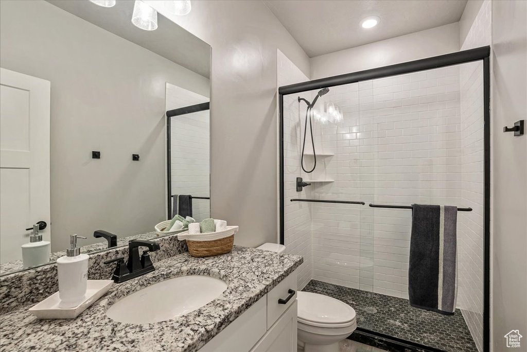 Bathroom featuring toilet, a shower stall, vanity, and recessed lighting
