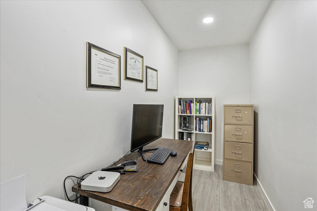 Home office with light wood finished floors and baseboards