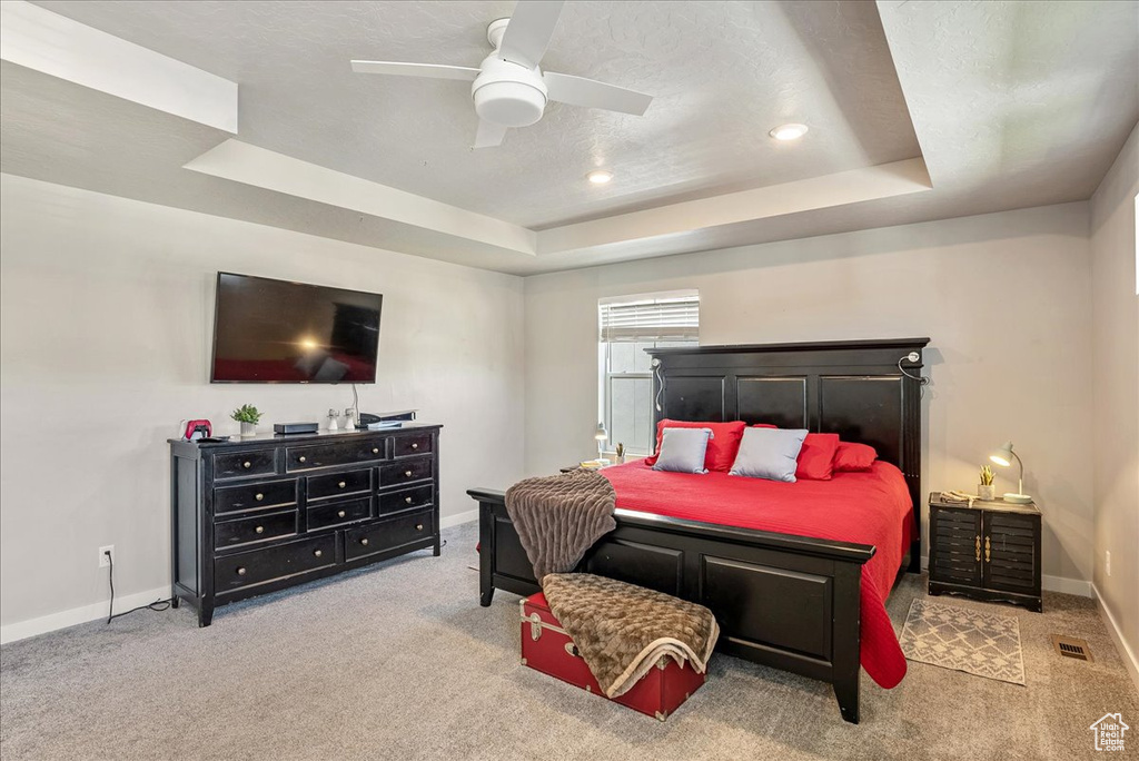 Bedroom featuring a tray ceiling, carpet floors, baseboards, recessed lighting, and ceiling fan