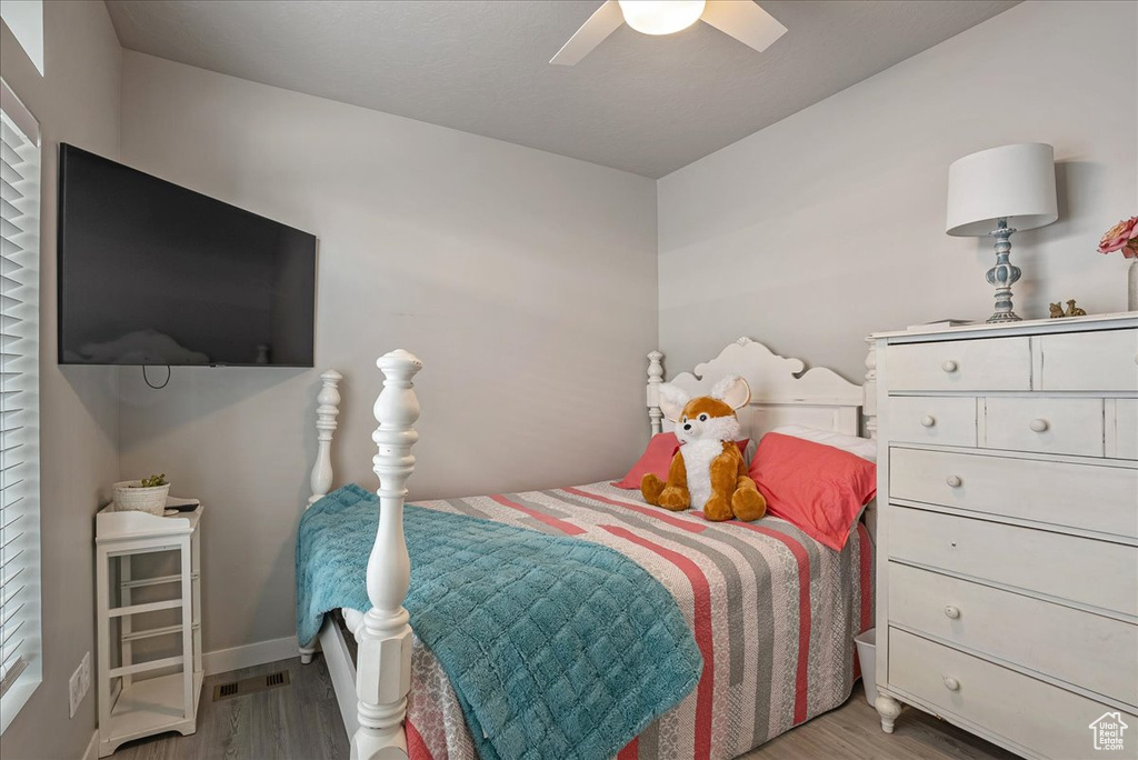 Bedroom with wood finished floors, baseboards, and a ceiling fan