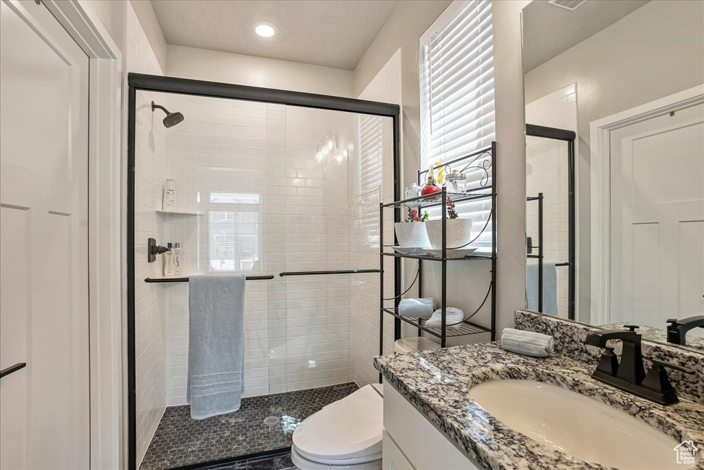 Bathroom with a shower stall, toilet, and vanity