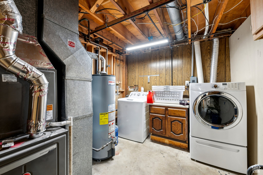 Laundry area with gas water heater, independent washer and dryer, and cabinet space