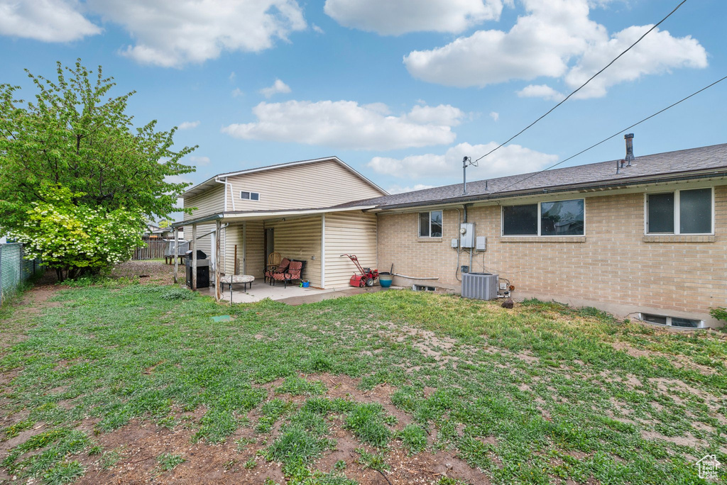 Back of property featuring brick siding and a patio area