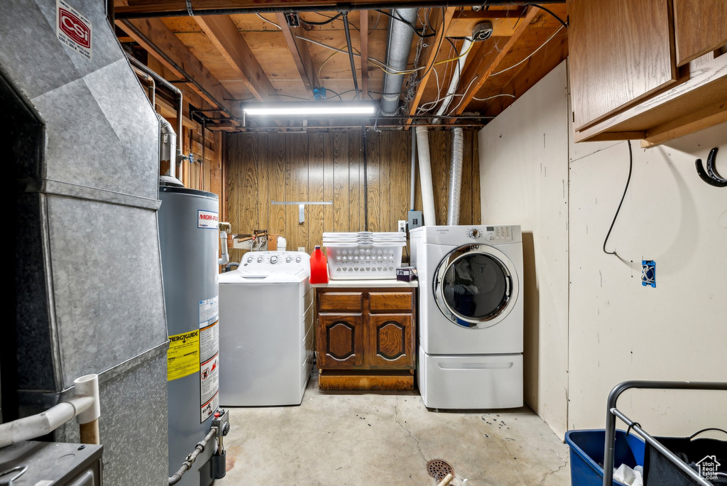 Clothes washing area with washer and dryer, water heater, cabinet space, and heating unit