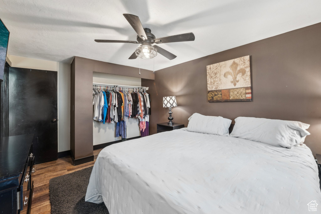 Bedroom with wood finished floors, a closet, a ceiling fan, and baseboards