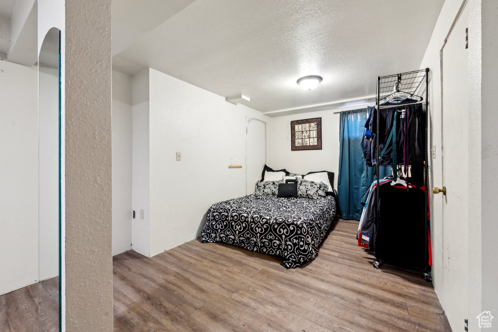 Bedroom featuring wood finished floors and a textured ceiling