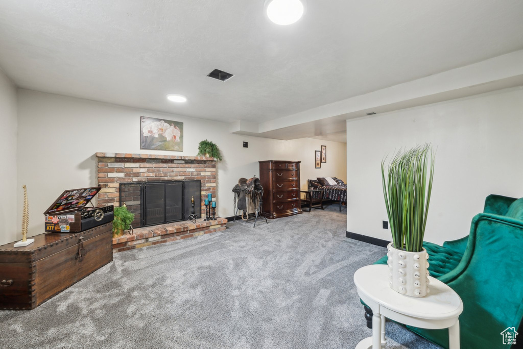 Carpeted living area with a fireplace and baseboards