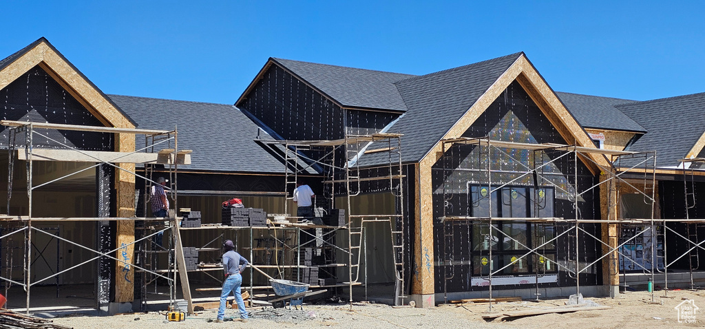 Back of property featuring a shingled roof