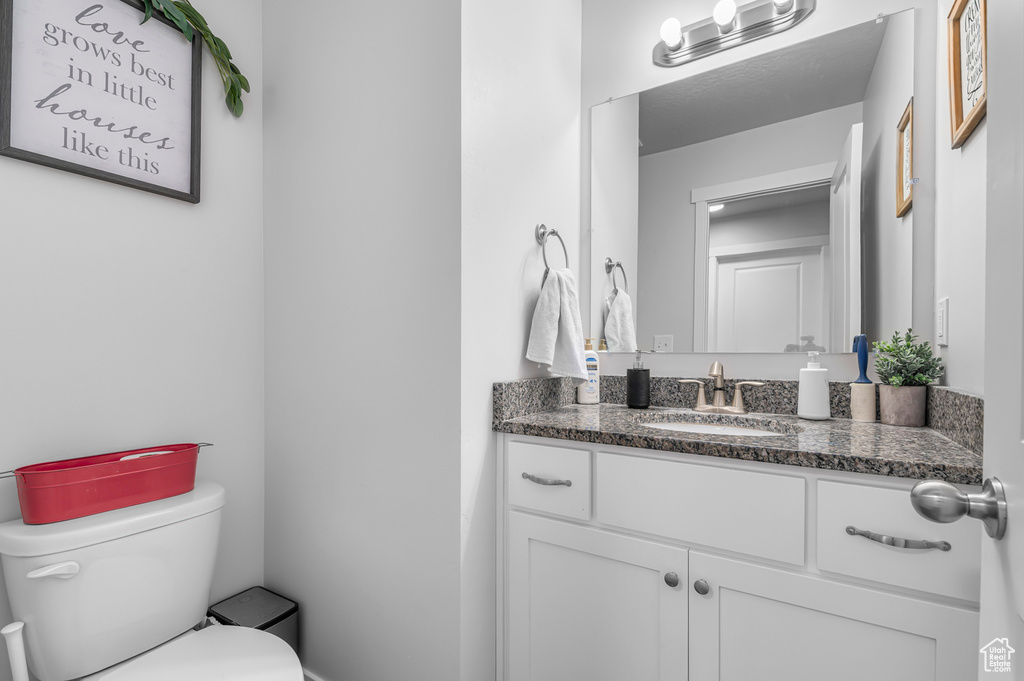 Half bathroom featuring toilet and vanity