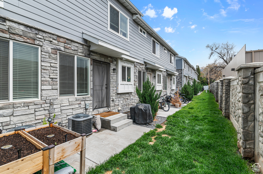 View of yard with central AC, a residential view, and a garden