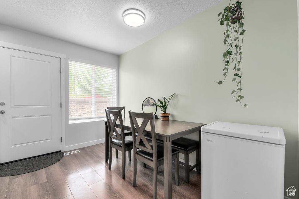 Dining room with baseboards, wood finished floors, and a textured ceiling