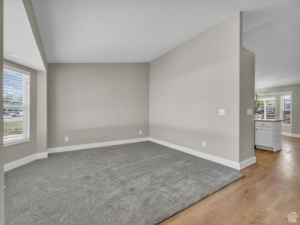 Empty room with baseboards, a healthy amount of sunlight, and wood finished floors