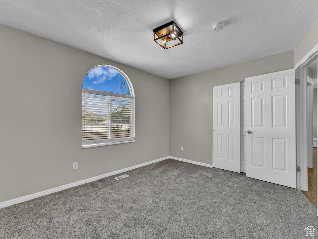 Unfurnished bedroom featuring baseboards, visible vents, and carpet