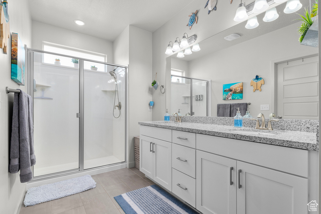 Bathroom with a shower stall, double vanity, and recessed lighting