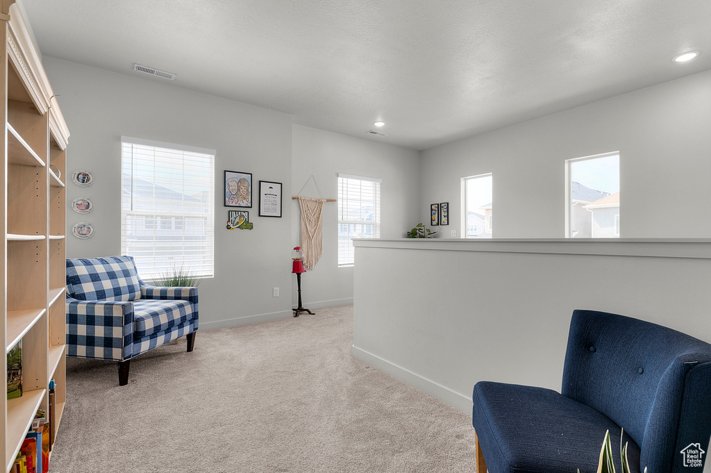 Sitting room with light carpet, baseboards, and recessed lighting