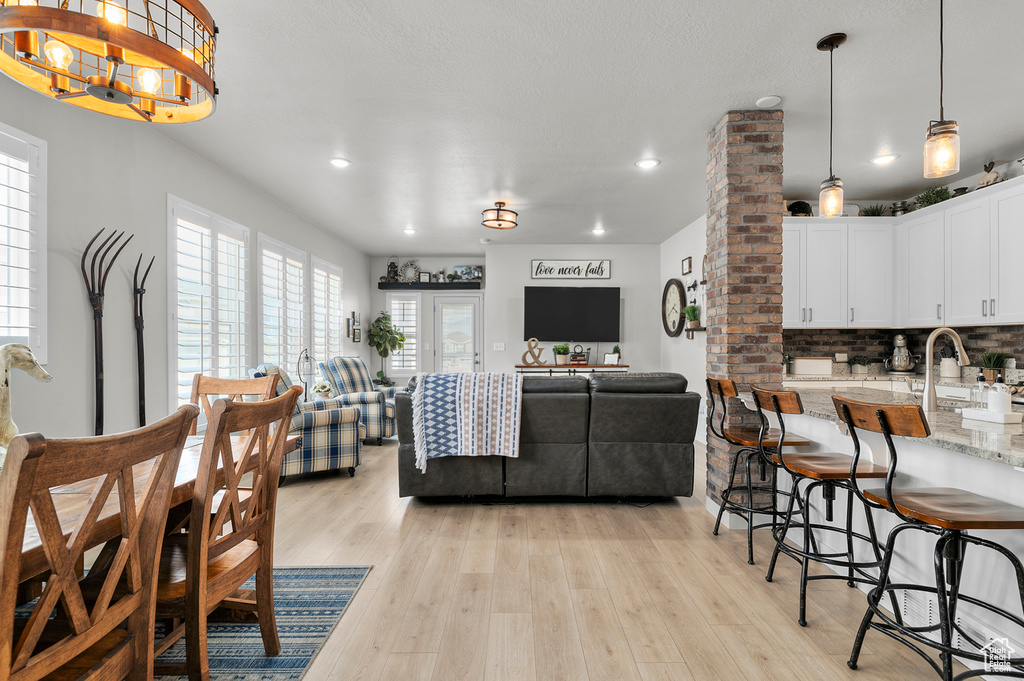 Dining area with recessed lighting, light wood-style floors, and a chandelier