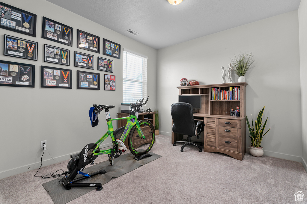 Carpeted home office featuring baseboards