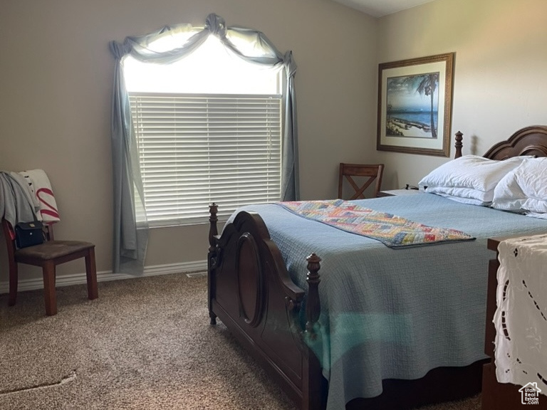 Carpeted bedroom featuring lofted ceiling, ceiling fan, and baseboards