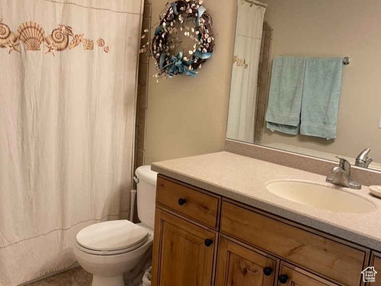 Full bathroom featuring toilet, vanity, tile patterned flooring, and a shower with shower curtain