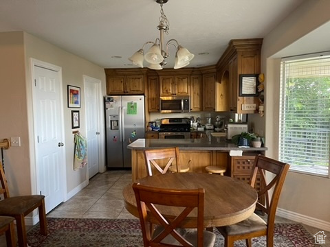Kitchen with stainless steel appliances, a chandelier, baseboards, and healthy amount of natural light