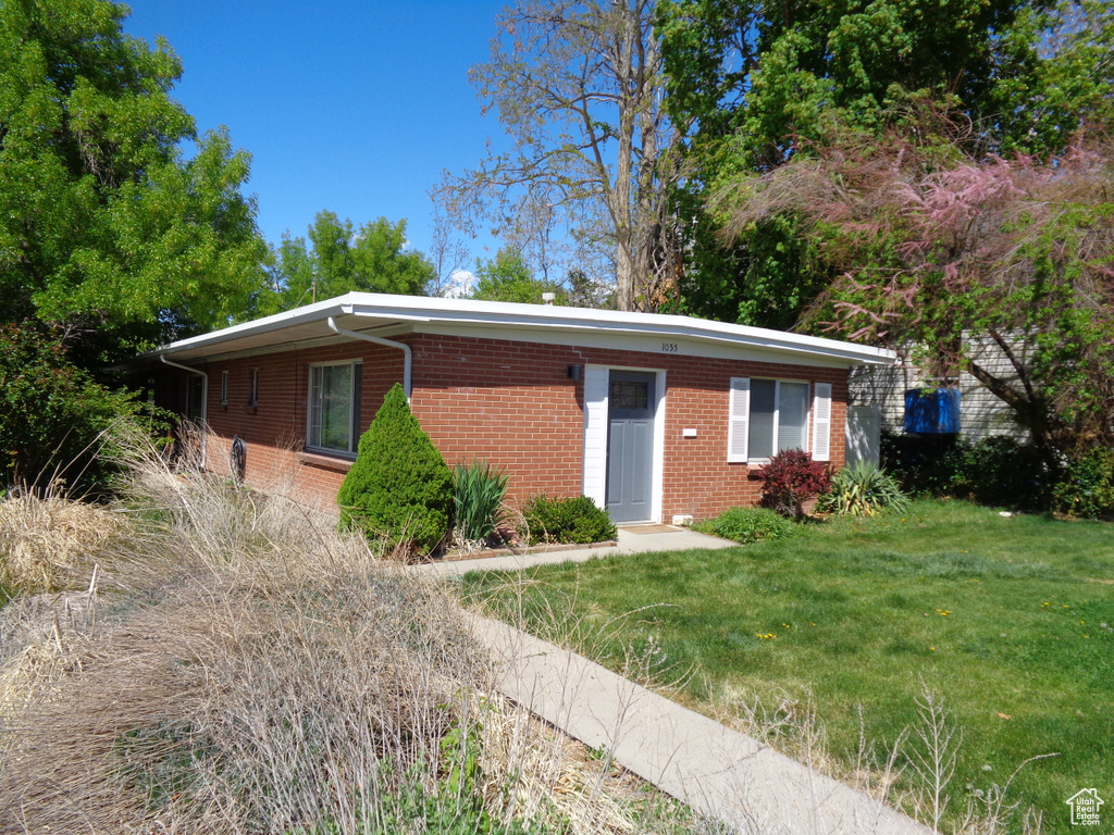 View of front facade featuring brick siding and a front yard