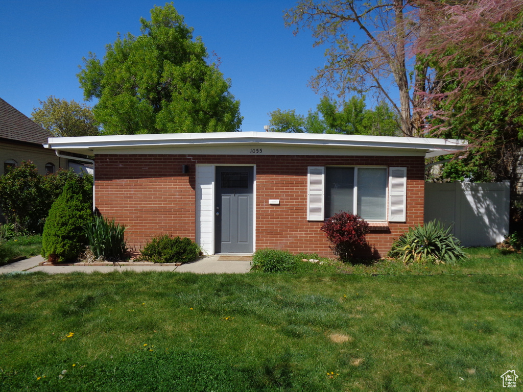 Ranch-style house with a front yard and brick siding