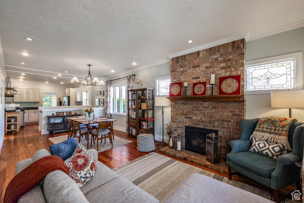 Living room featuring a fireplace, dark wood-style floors, recessed lighting, a chandelier, and baseboards