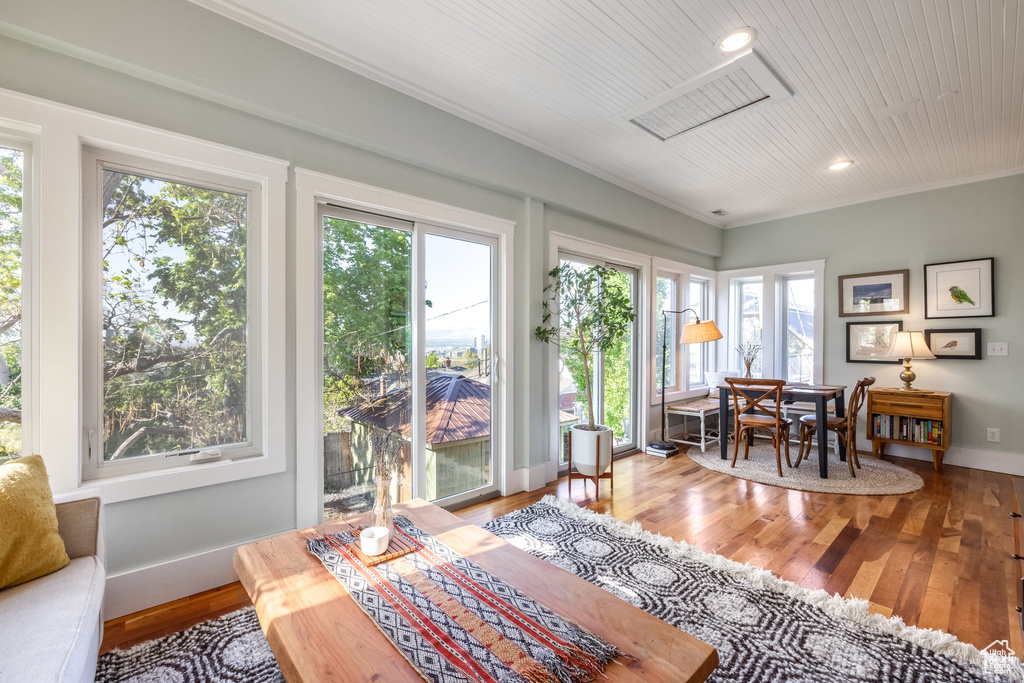 Sunroom / solarium with baseboards, wood finished floors, recessed lighting, crown molding, and wood ceiling
