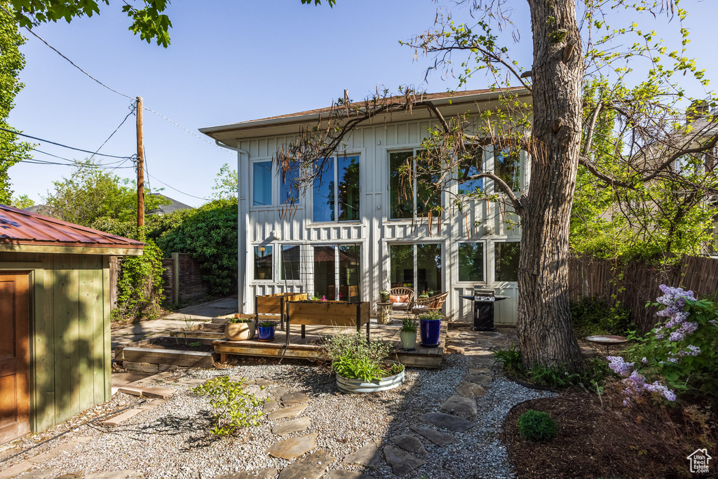 Rear view of property featuring fence, a wooden deck, and board and batten siding