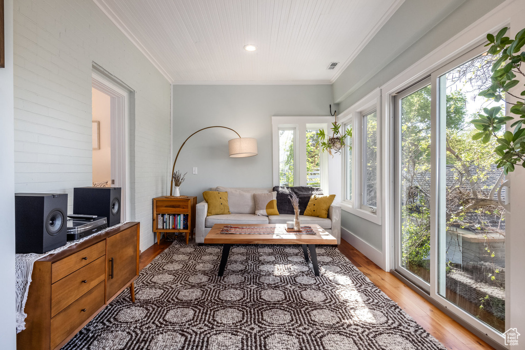 Living room featuring light wood-style flooring, ornamental molding, baseboards, and recessed lighting