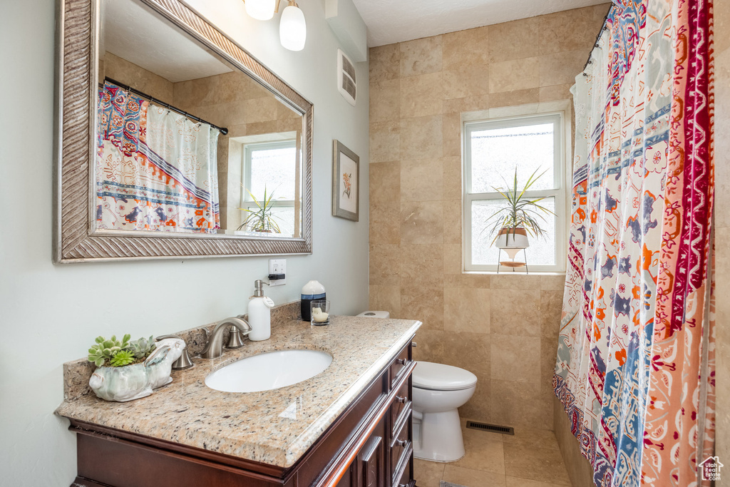 Full bathroom with toilet, vanity, a shower with curtain, and tile patterned flooring