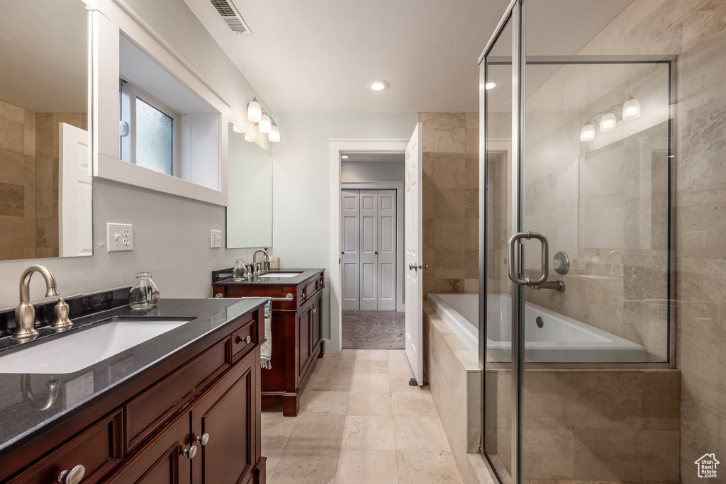 Bathroom featuring two vanities and recessed lighting