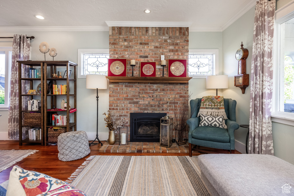 Living room with baseboards, wood finished floors, healthy amount of natural light, crown molding, and recessed lighting