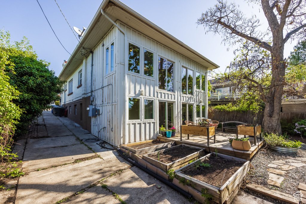 View of side of property featuring a vegetable garden, board and batten siding, a patio, and fence