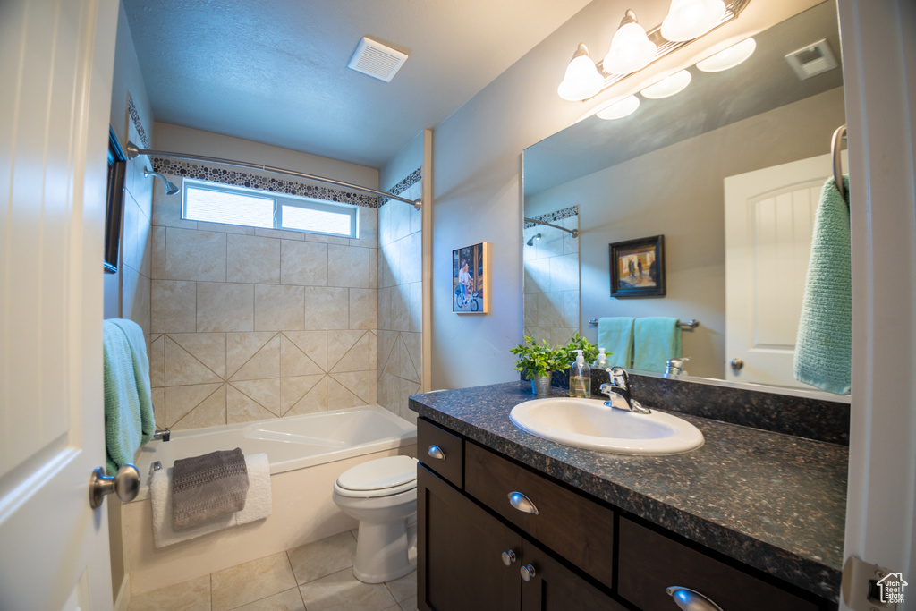 Bathroom featuring tile patterned floors, toilet,  shower combination, and vanity
