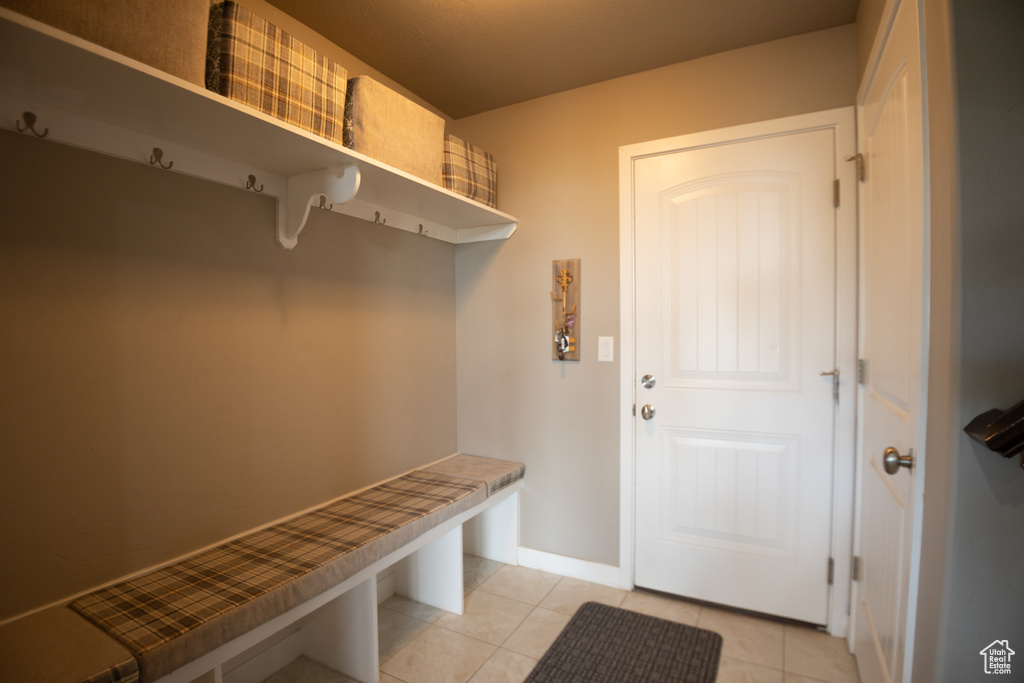 Mudroom featuring light tile patterned flooring and baseboards