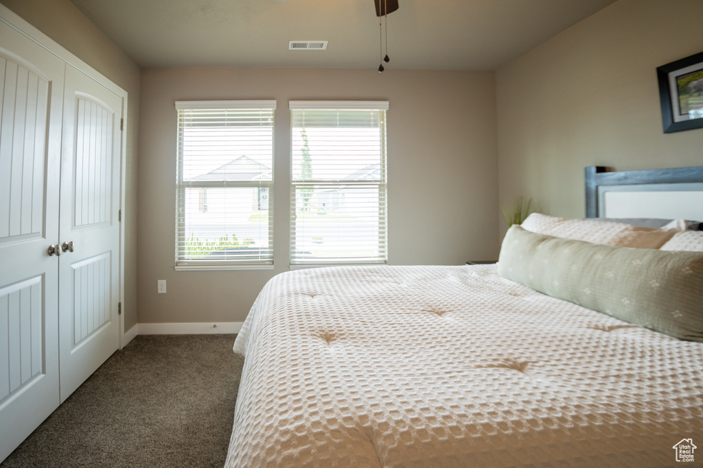 Bedroom featuring carpet floors, a closet, baseboards, and a ceiling fan