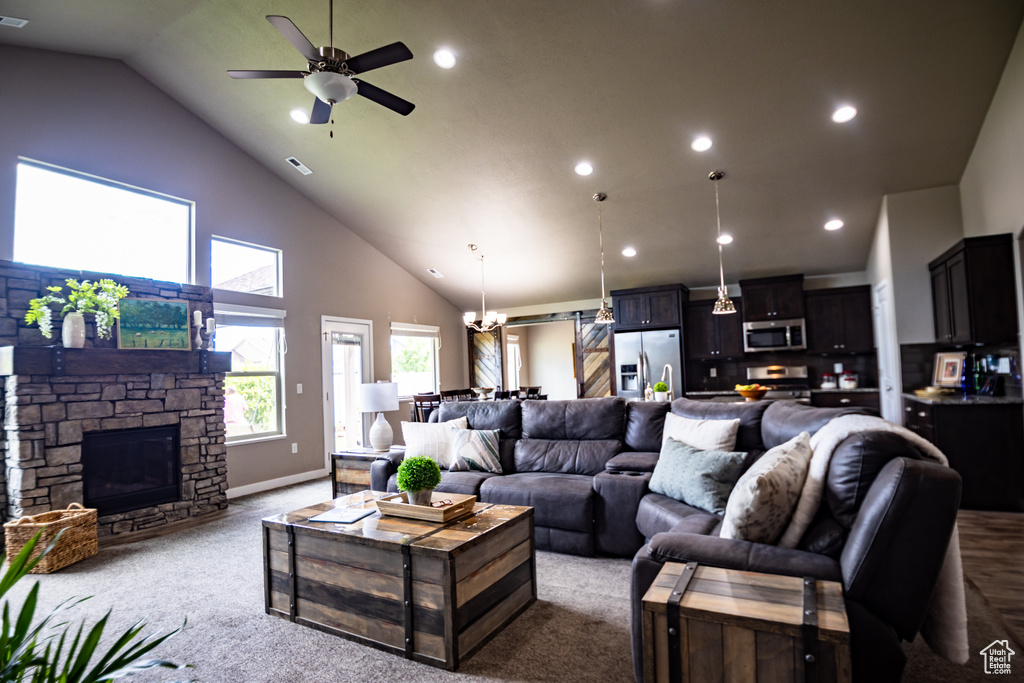 Living area featuring high vaulted ceiling, carpet flooring, a fireplace, a ceiling fan, and recessed lighting