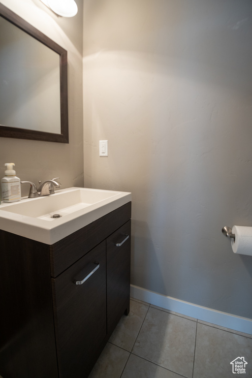 Bathroom featuring vanity, tile patterned flooring, and baseboards